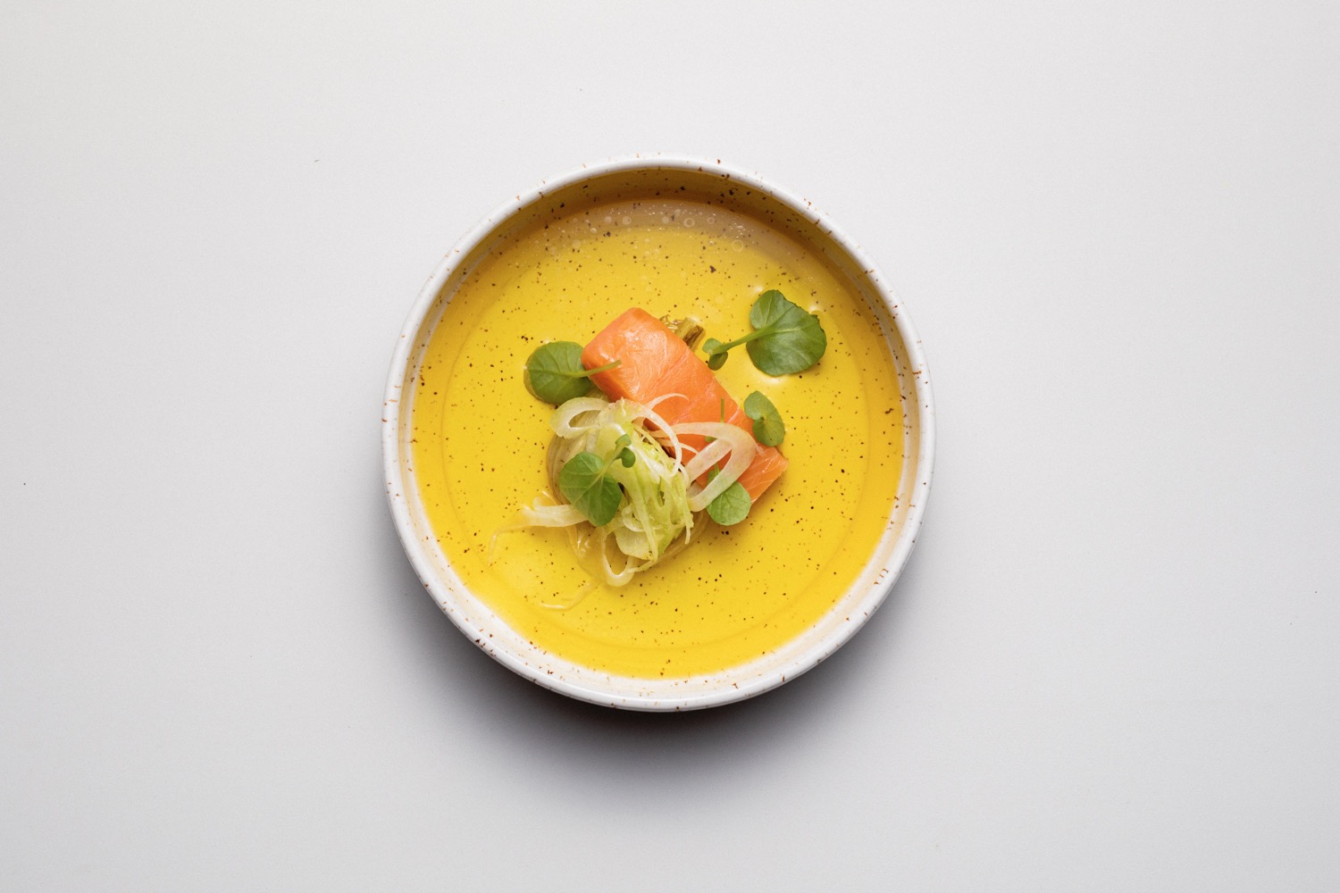 Lachssuppe serviert in einem weißen Suppenteller