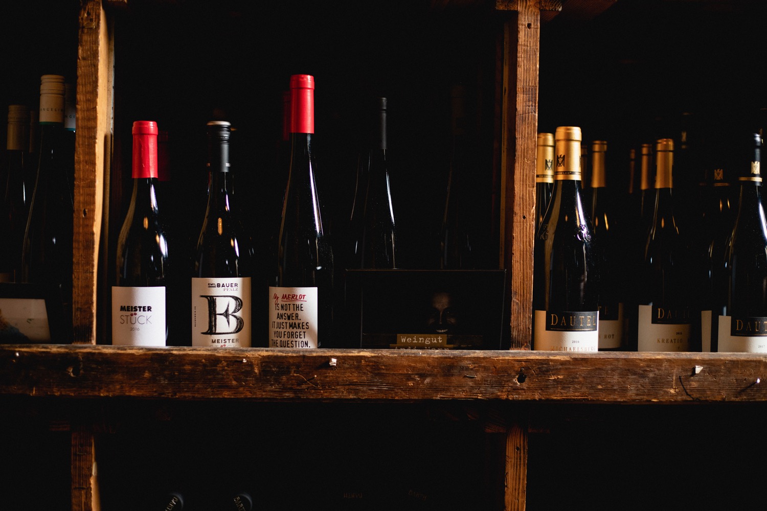 Weinregal mit verschiedenen Weinflaschen mit rotem Verschluss